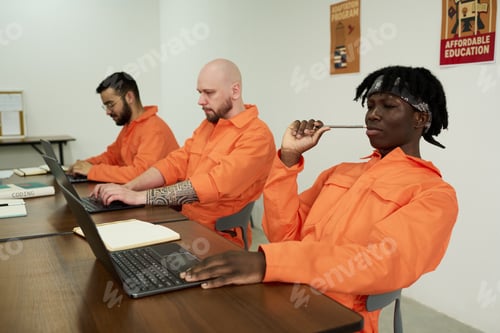 Preview: Young Adult Men of Diverse Ethnicities Working on Laptops in Classroom Setting