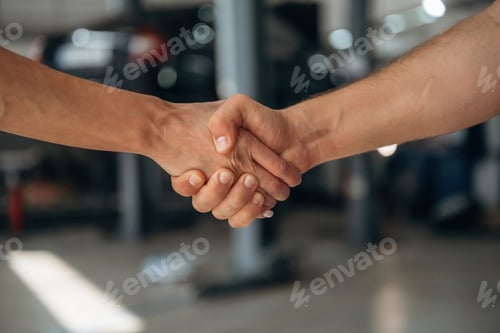 Preview: Handshake of man and woman in the car repair service station