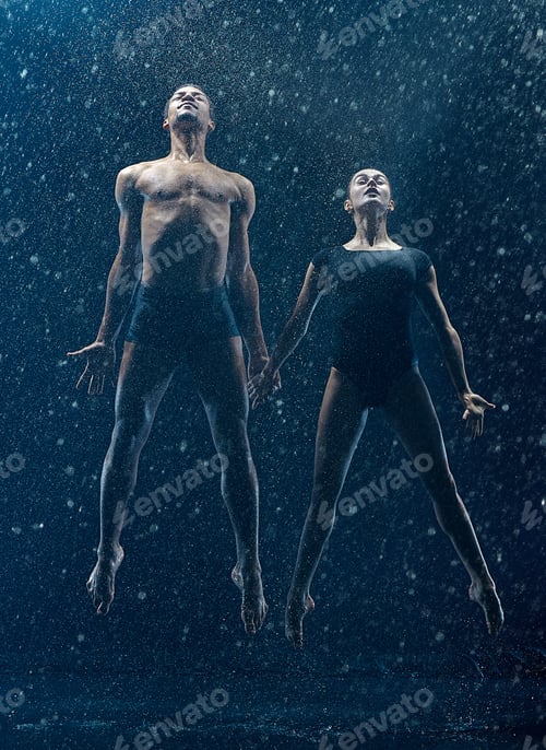 Preview: Young couple of ballet dancers dancing unde rwater drops