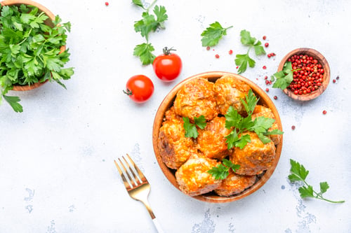 Preview: Meatballs with tomato sauce in bowl on white table background. Top view
