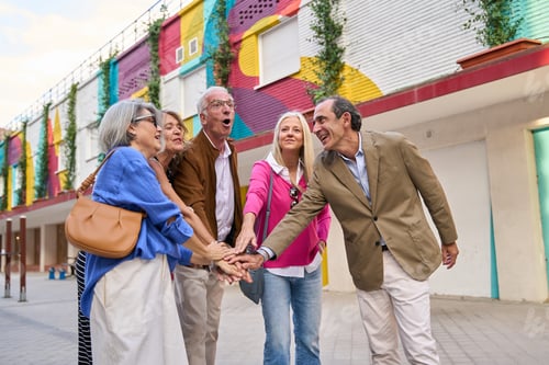 Preview: Senior friends stacking hands celebrating teamwork