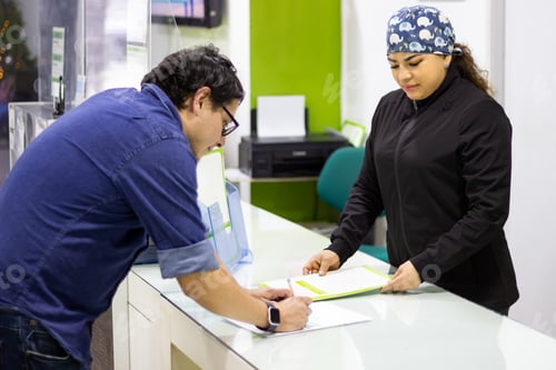 Preview: Patient signing documents at clinic reception desk