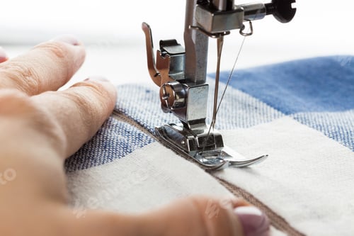 Preview: Sewing a fabric piece with a sewing machine in a bright indoor workshop