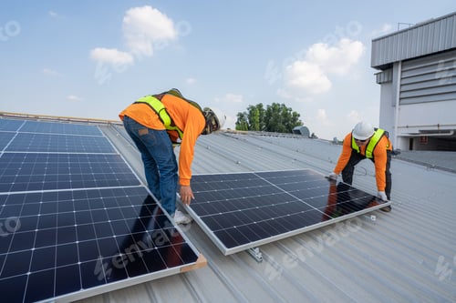 Preview: Men technicians carrying photovoltaic solar moduls on roof.