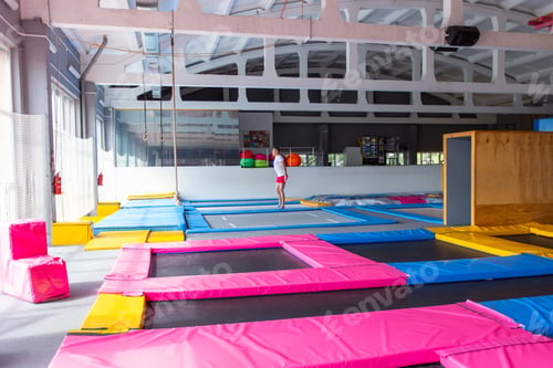 Preview: Fitness, fun, leisure and sport activity concept - Handsome happy man jumping on a trampoline
