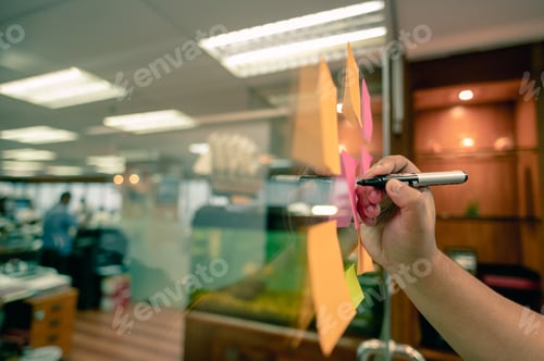 Preview: Hand writing paper note, sticky note on glass window with close up shot.