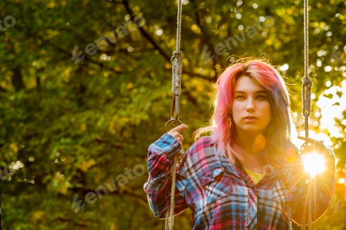 Preview: Portrait of teenage girl with multi-coloured hair, on garden swing