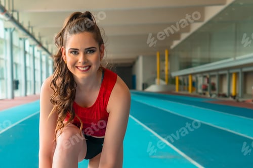 Preview: Indoor athletics, portrait of female sprinter preparing shoes for training