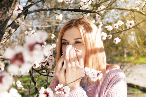 Preview: Woman suffering from seasonal allergy outdoors on sunny day