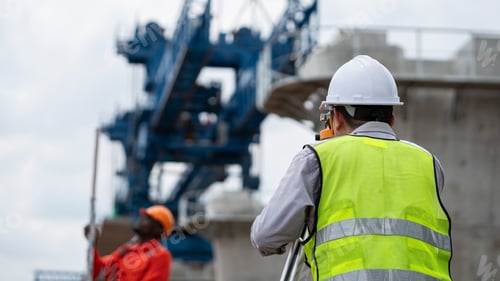 Preview: The survey team is operating a theodolite while referencing road construction plans.