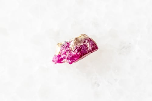 Preview: sample of rough pink ruby mineral on white marble