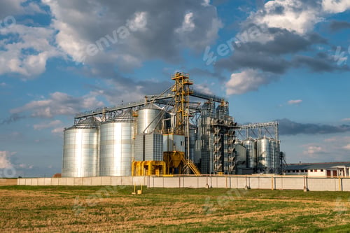 Aperçu: silos d'argent sur une usine de fabrication agricole pour le traitement, le séchage, le nettoyage et le stockage