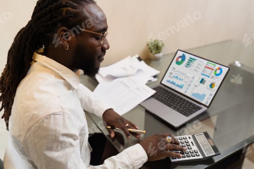 Preview: Businesswoman using a calculator to calculate numbers on a company's financial documents, she is