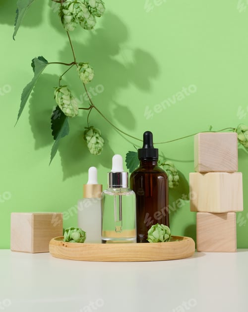 Preview: Glass bottles with pipettes for liquid cosmetics on a wooden stand