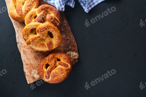 Preview: Bavarian pretzels and glass of lager beer. Oktoberfest food menu, traditional salted pretzels on bla
