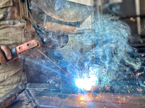 Preview: Unrecognizable diverse metal worker uses special tool to weld metal making sparks and smoke