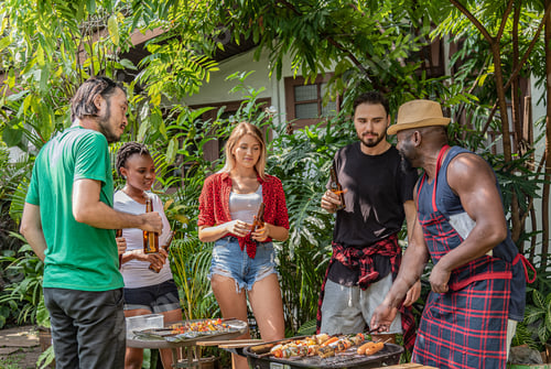 Preview: Group of friends diversity making barbecue in the garden backyard