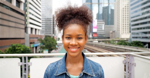 Preview: Portrait of smiling happy woman walking in street with backpack