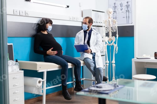 Preview: Physician consulting expectant adult at medical appointment
