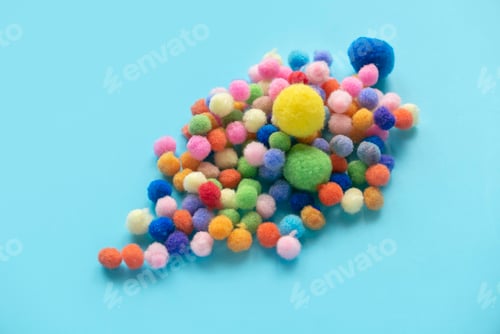 Preview: Colorful pom pom cotton ball isolated on blue background. For montessori.