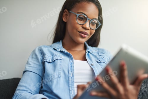 Preview: Woman with glasses using tablet in home setting