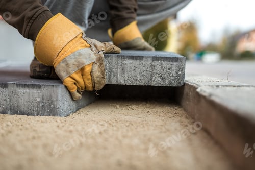 Preview: Workman laying exterior paving stones