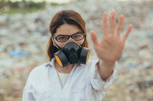 Preview: A woman in a protected respiratory suit at landfills, holding hands in front, trying to stop the