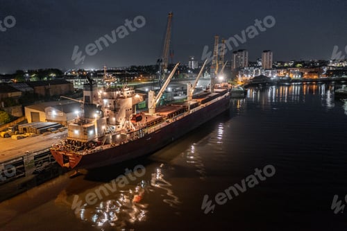 Preview: Cargo Ship Docked at a Port at Night Offloading Cargo