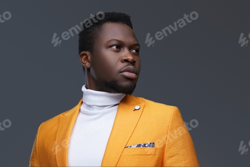 Preview: African man in orange coat against gray background