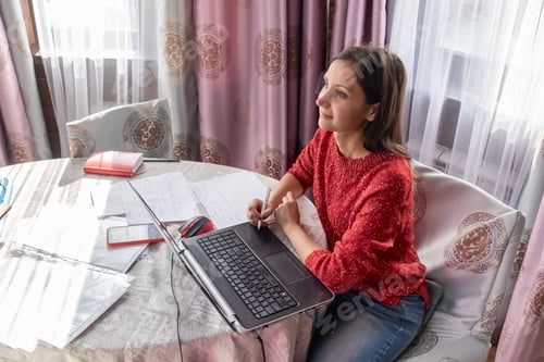 Preview: Woman Working at Home with Laptop and Papers