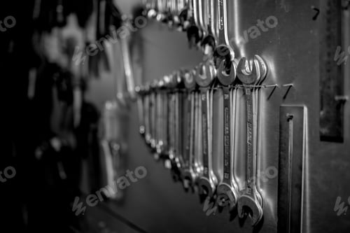 Preview: Grayscale selective focus shot of a repair metal key Instruments hanging on the wall