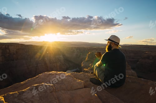 Preview: Man drinking near canyon