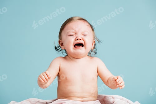 Preview: Sad baby sitting down and crying.