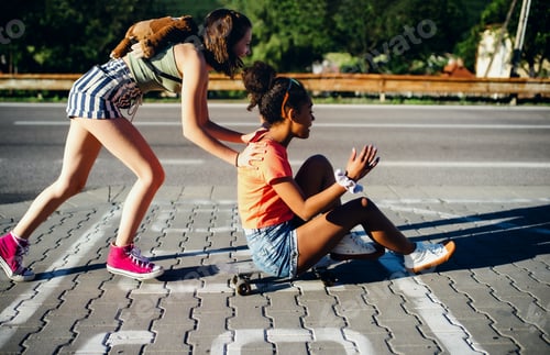 Preview: Teenager girls friends with skateboards outdoors in city, having fun