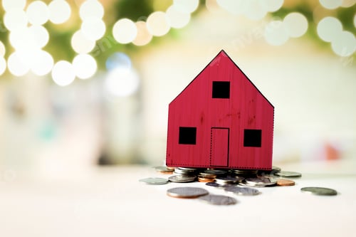 Preview: Small red house standing on a heap of coins.