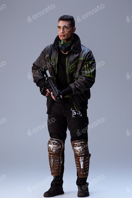 Preview: handsome bi-racial cyberpunk player holding gun and standing on grey