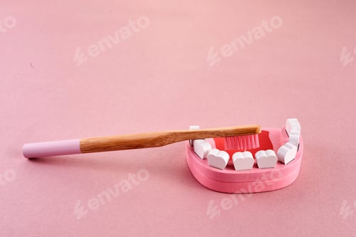 Preview: National brush day. Tooth with toothbrush on pink background. Dental health concept.