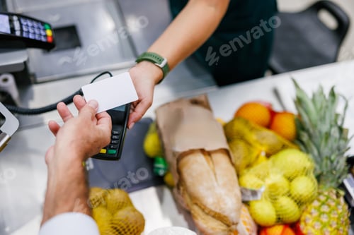 Preview: Customer paying with contactless credit card at supermarket checkout