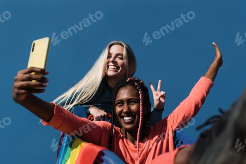 Preview: Young multiracial lesbians having fun outdoors taking a selfie with smartphone - Lgbt and pride