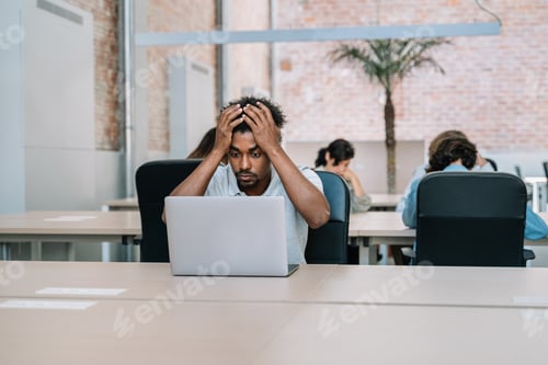 Preview: African American Man Shocked Reading Message on Computer in Office