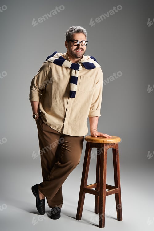 Preview: Stylish man in elegant outfit poses confidently in modern studio setting