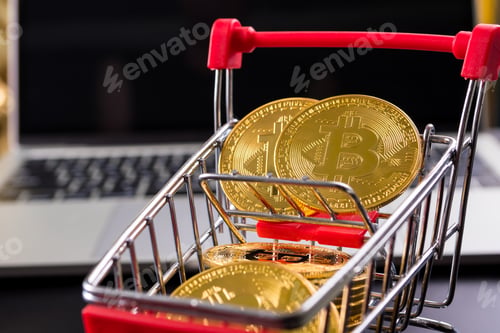 Preview: Golden coins with bitcoin symbol in a little shopping cart with computer background.