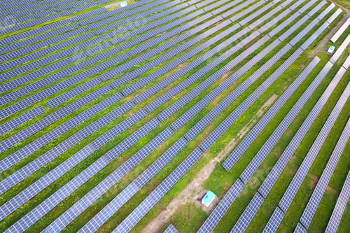 Preview: Aerial view of solar power plant on green field. Electric panels for producing clean ecologic energy