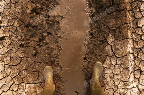 Preview: Boots Standing in Dry Cracked Muddy Field