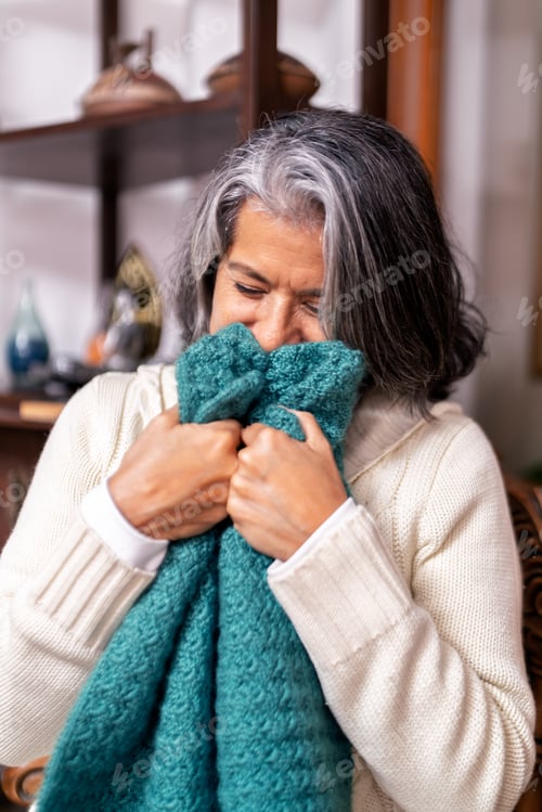 Preview: Senior woman enjoying the softness of a knitted shawl