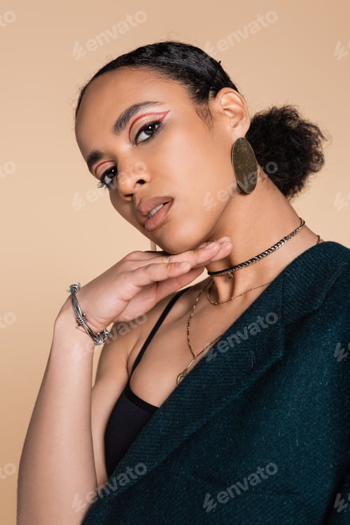 Preview: portrait of charming african american model in dark blue oversized blazer posing isolated on beige