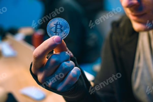 Preview: cropped shot of hacker holding bitcoin in dark room