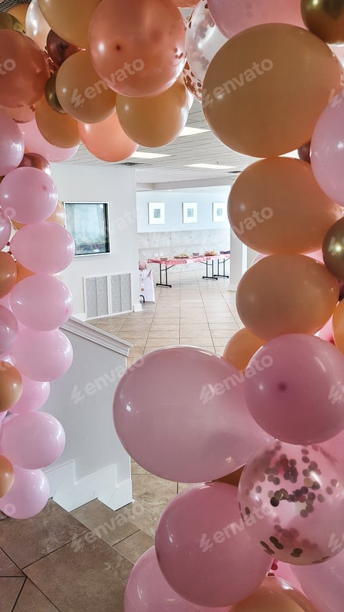 Preview: Pink balloons line a door leading into future baby shower.