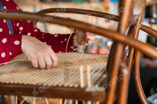 Preview: Hands weaving rattan cane for chair seat restoration