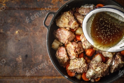 Preview: Adding broth in the pan with meat and vegetable top view
